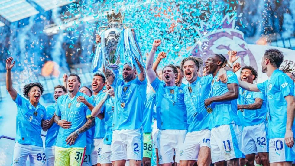 Manchester City players celebrating with the Premier League trophy